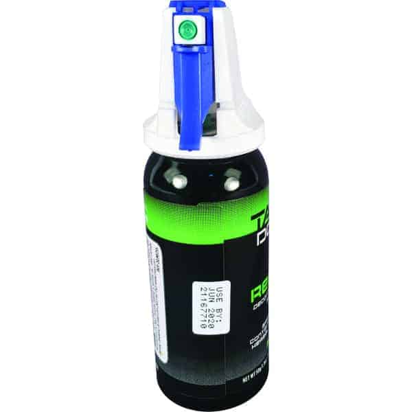 Green and black tactical defense spray can with a blue safety cap, labeled with a use-by date.