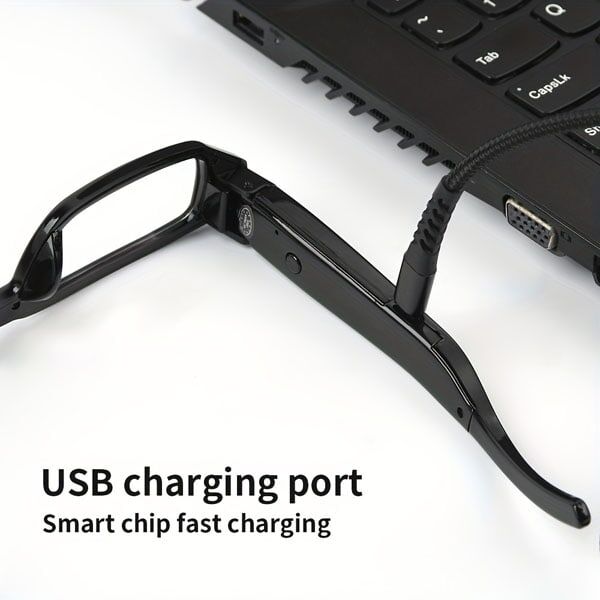 Smart glasses with USB charging cable connected to laptop, highlighting fast charging technology.