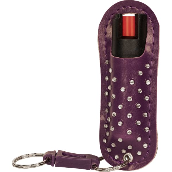 Purple pepper spray keychain in studded leather case for personal safety.