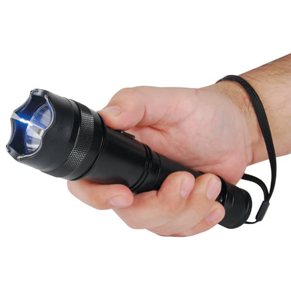 Hand holding a black flashlight with a bright blue light, featuring a wrist strap for secure grip and portability.