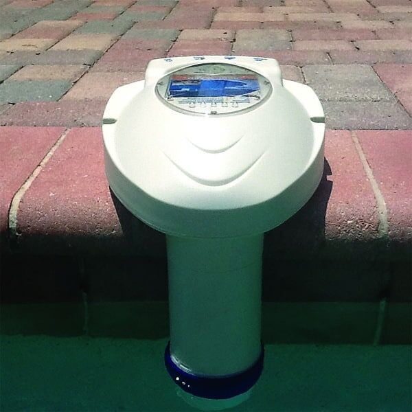 Pool thermometer on brick edge measuring water temperature.