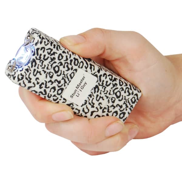 Hand holding a leopard print stun gun with bright light flashing, enhancing personal safety.