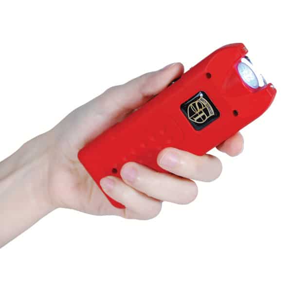 Red stun gun flashlight held in a person's hand, showcasing safety and self-defense tool.